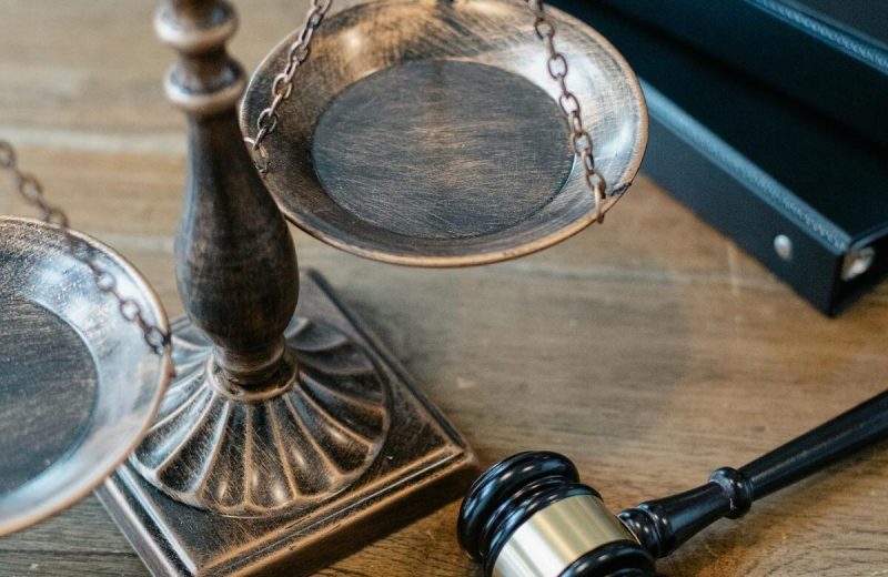Justizwaage und Richterhammer auf Holztisch